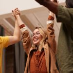 Joyful friends celebrating together with hands uplifted, symbolizing unity and happiness.